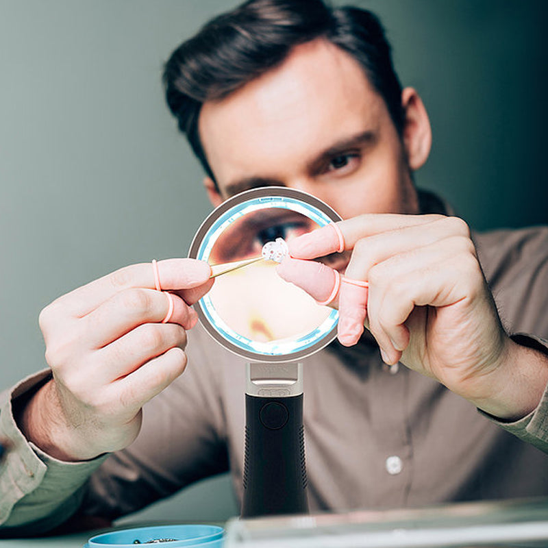 Close Up of Man Looking at Jewelry through Magnifying Glass Stock